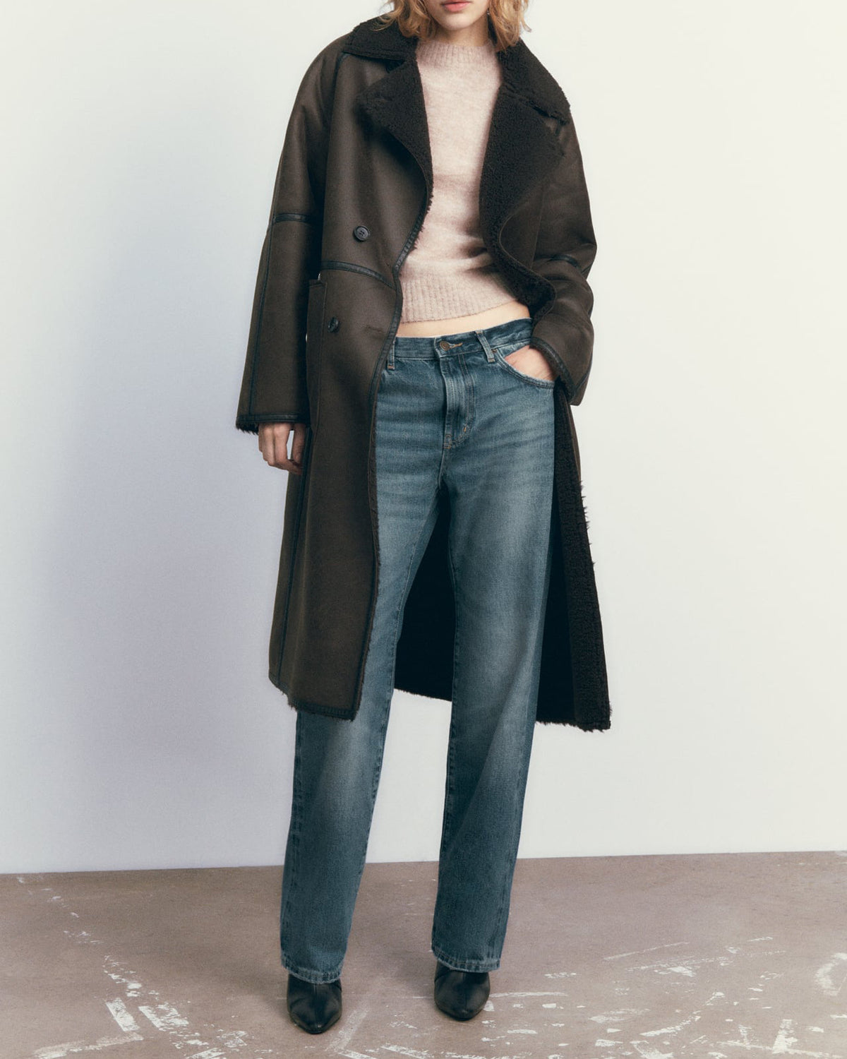 Woman in a belted faux shearling coat