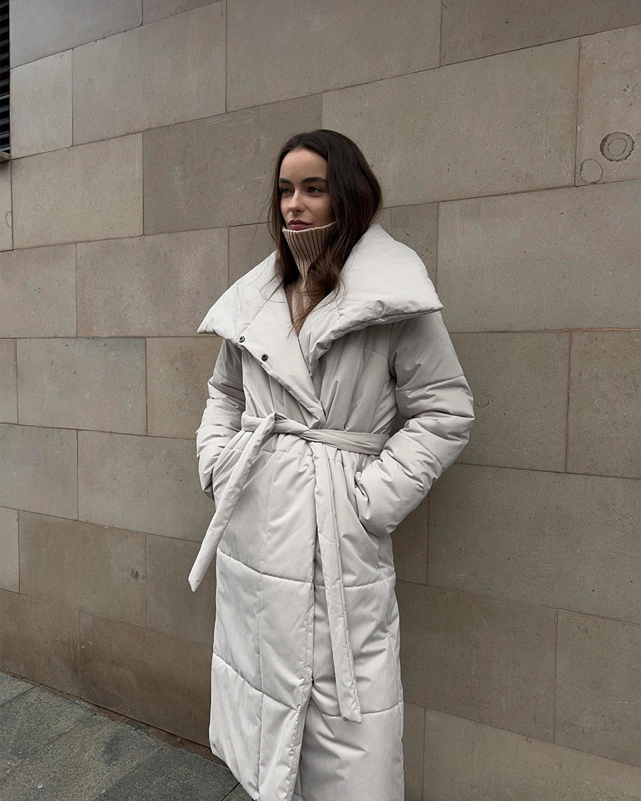 Woman in a long quilted belted coat