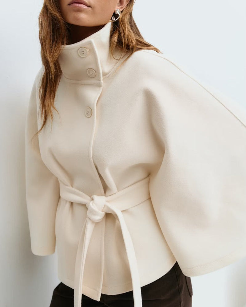 Woman in belted cape coat with high collar