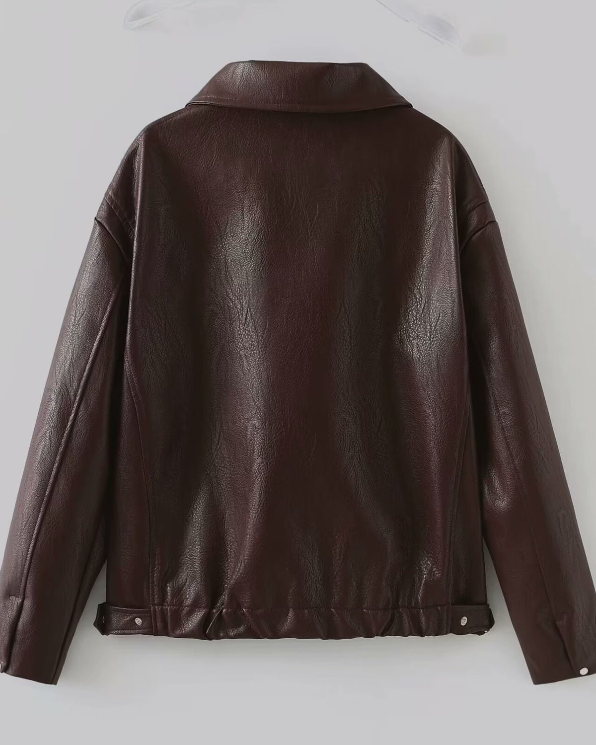 Woman in a cropped burgundy leather jacket