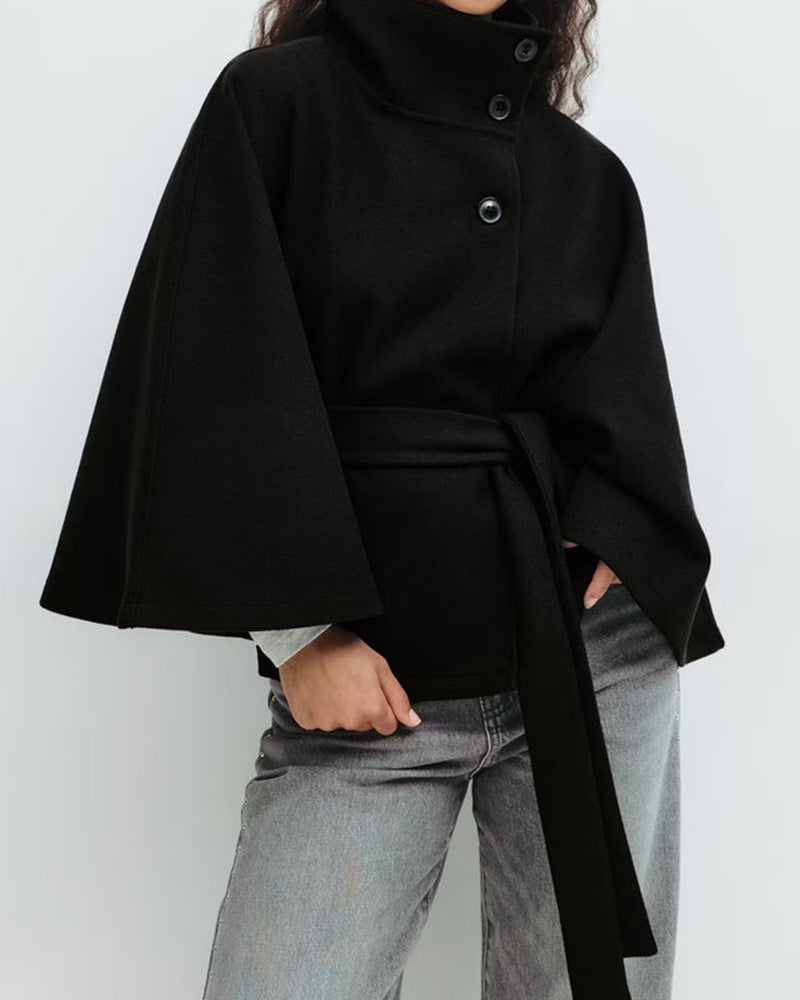 Woman in belted cape coat with high collar