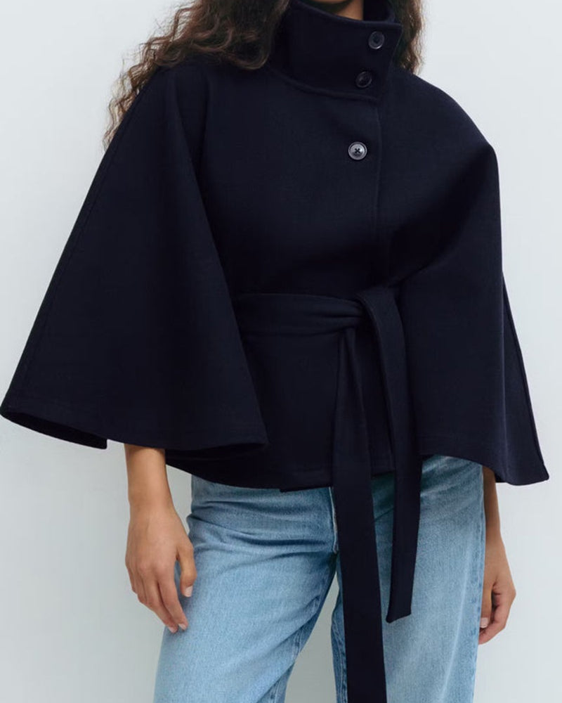 Woman in belted cape coat with high collar