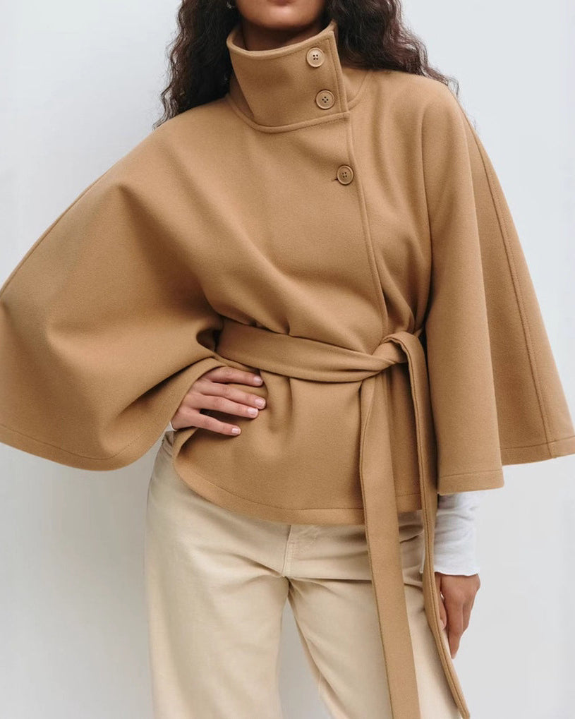 Woman in belted cape coat with high collar
