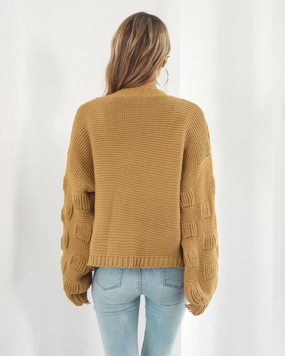 Woman in chunky cable knit puff sleeve cardigan