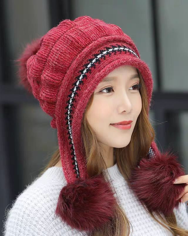 Woman in an ear flap beanie with pompom