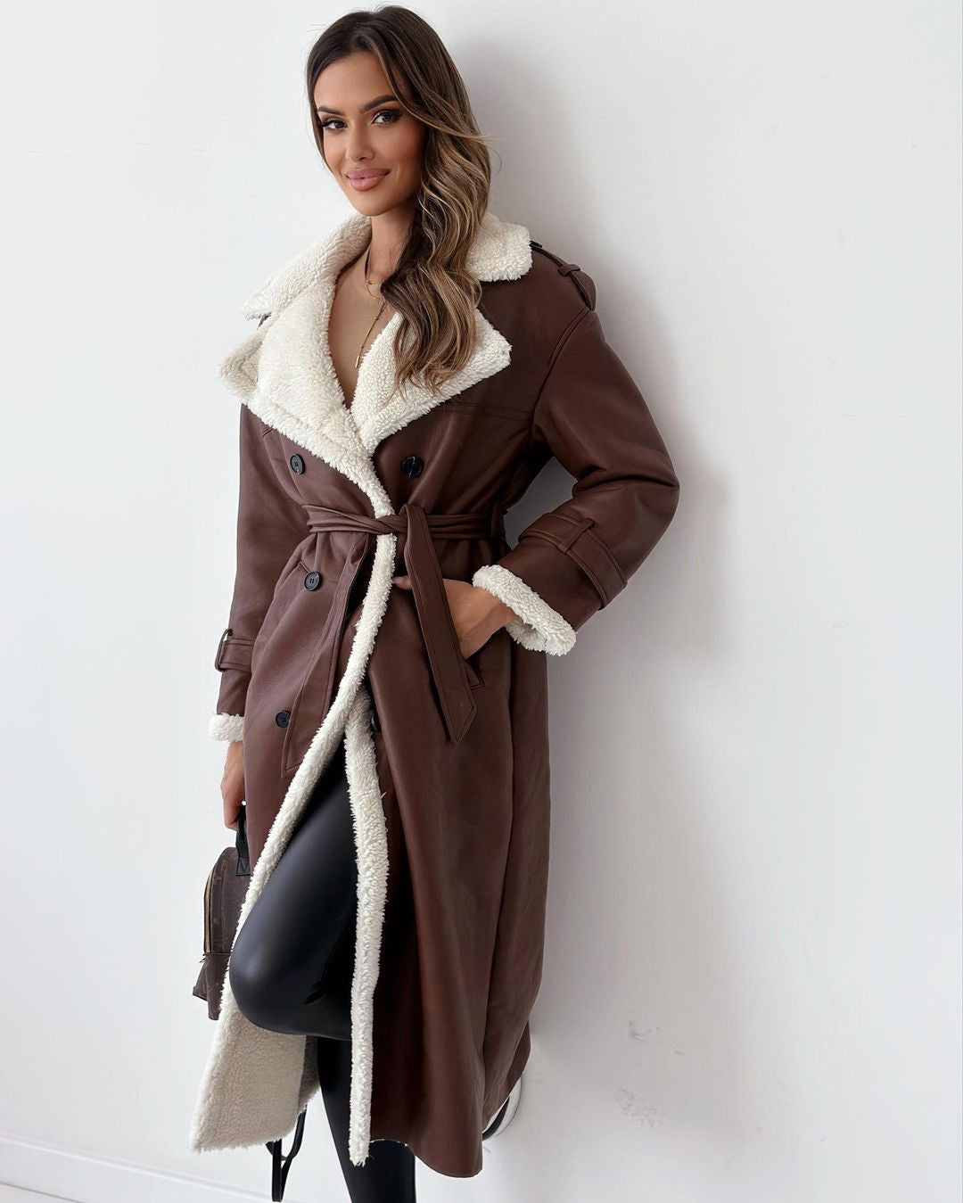 Woman in a belted faux shearling coat